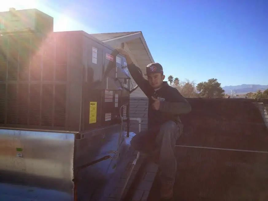 HVAC technician performing HVAC Inspection on a rooftop unit in Almont